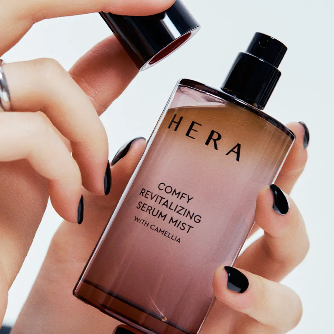 Flacon de HERA Comfy Revitalizing Serum Mist 90ml tenu dans la main, soin du visage pour une hydratation immédiate et revitalisante.