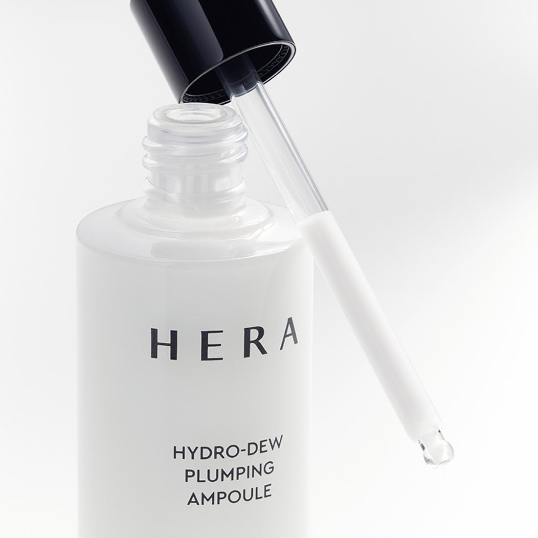 Flacon de HERA Hydro-Dew Plumping Ampoule 50ml avec pipette ouverte, produit de soin hydratant et repulpant.