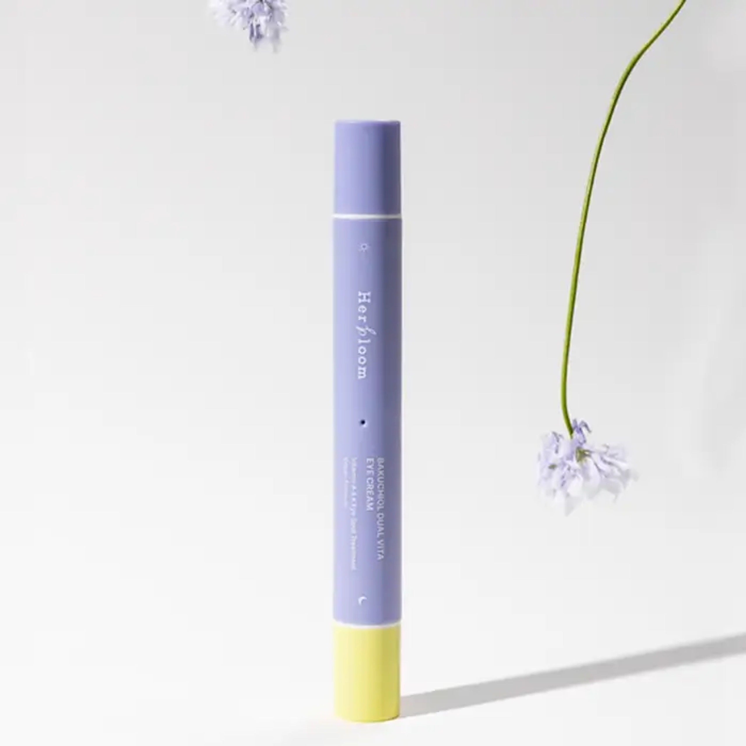 HERBLOOM Bakuchiol Dual Vita Eye Cream : flacon bleu et jaune sur fond clair, fleurs délicates en décor visuel