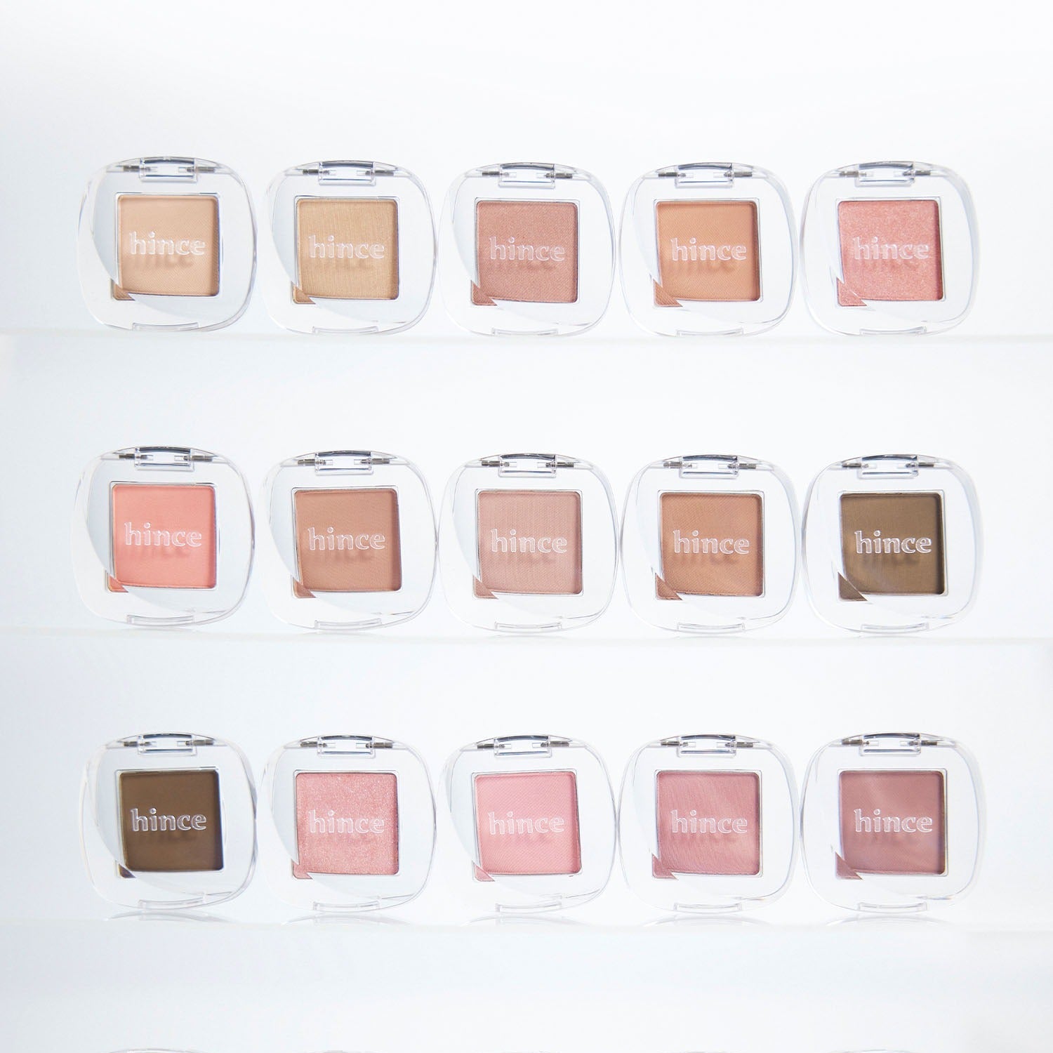 HINCE Single Eyeshadow de la marque HINCE, palette de nuances en boîtiers transparents sur fond clair.