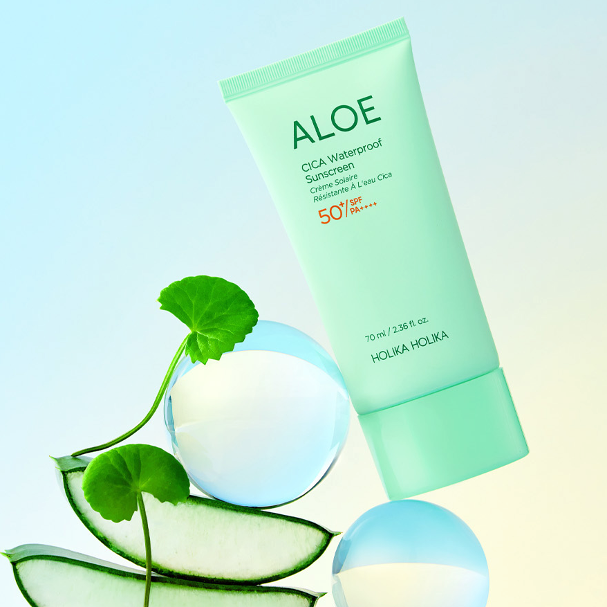 Décrivez l'image : HOLIKA HOLIKA Aloe Cica Waterproof Sunscreen 70ml, tube vert avec aloe, concombres et billes bleues.