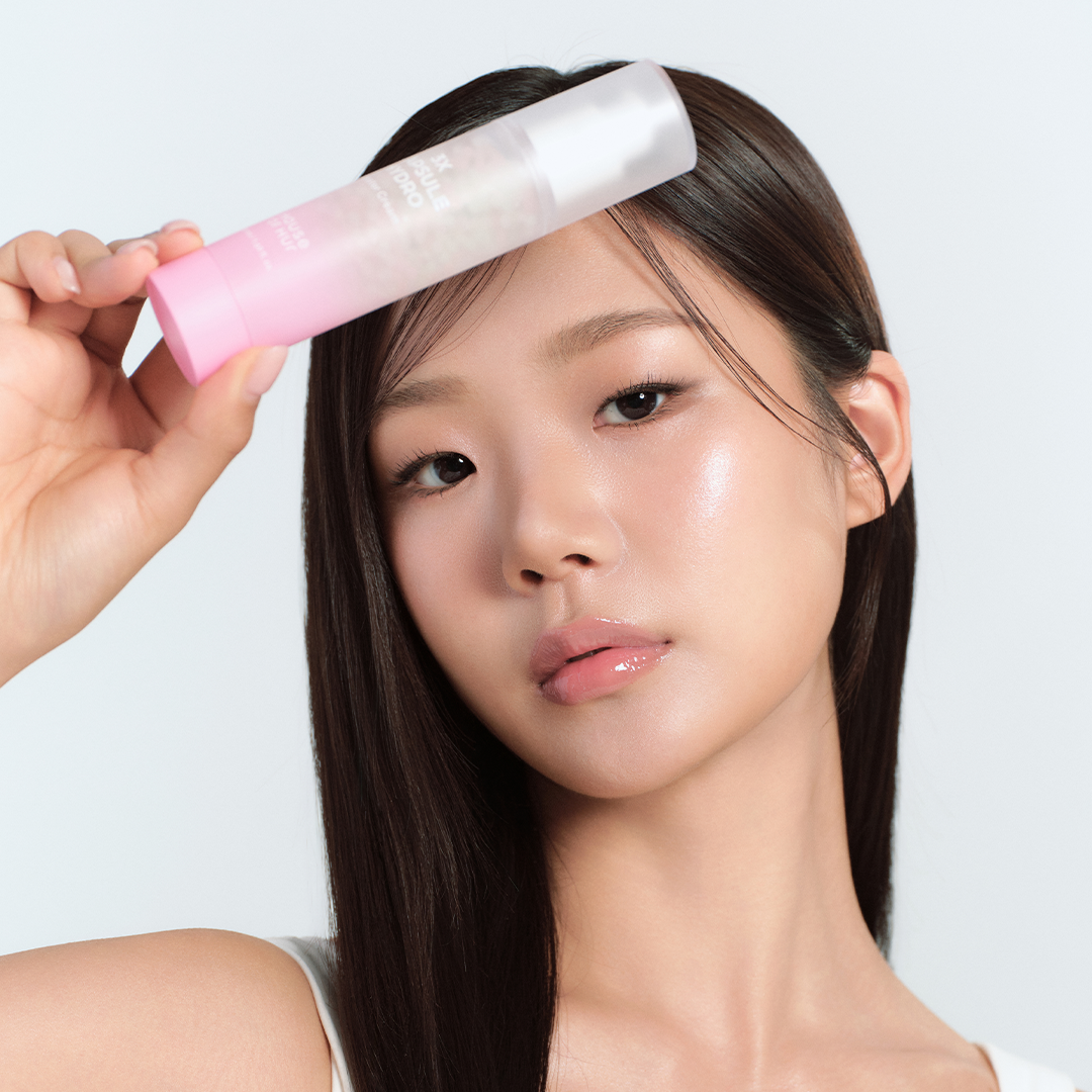 HOUSE OF HUR 3X Capsule Hydro Booster Cream 50ml, la femme applique la crème hydratante, pack rose sur fond clair.
