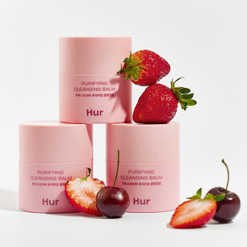 HOUSE OF HUR Purifying Cleansing Balm, baume rose sur fond clair avec fraises et ingrédients, photo produit en studio.