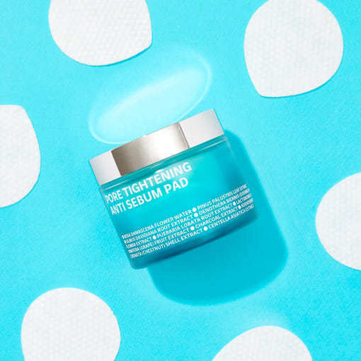 ISOI Pore Tightening Anti-Sebum Pads 60 Sheets sur fond bleu avec motifs, pot et pastilles anti-sébum, contexte visuel soins visage.