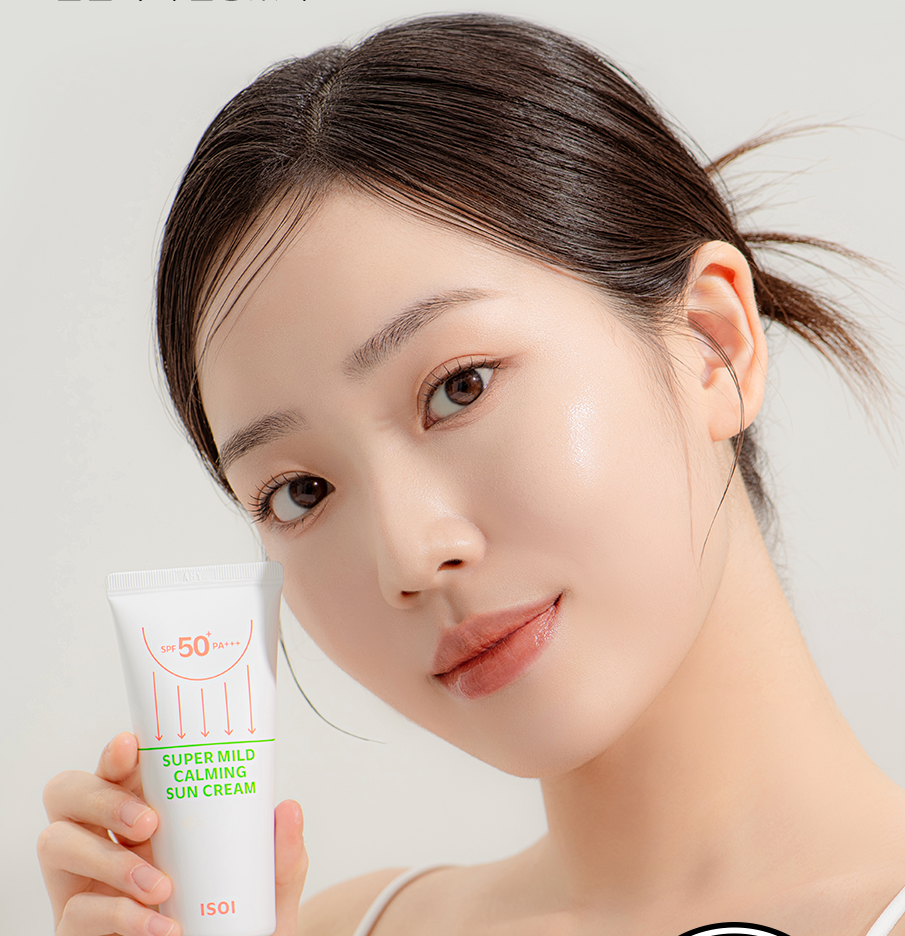 Femme tenant ISOI Super Mild Calming Sun Cream SPF50+PA++++ 55ml, crème solaire apaisante pour peaux sensibles.