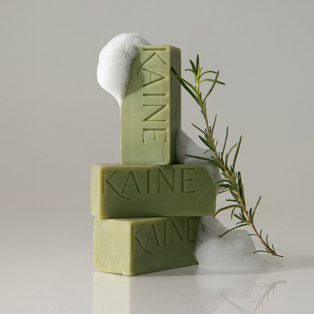 KAINE Rosemary Acne Mildly Acidic Cleansing Bar 100g, savon vert avec mousse et romarin, marque KAINE sur fond clair.