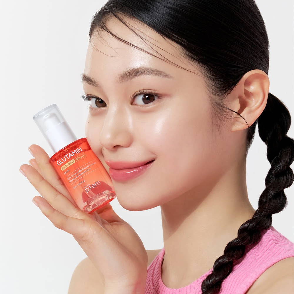 Femme souriante tenant le MAKE P:REM Glutamine Antioxidant Radiance Serum 50ml, sérum éclat et antioxydant.