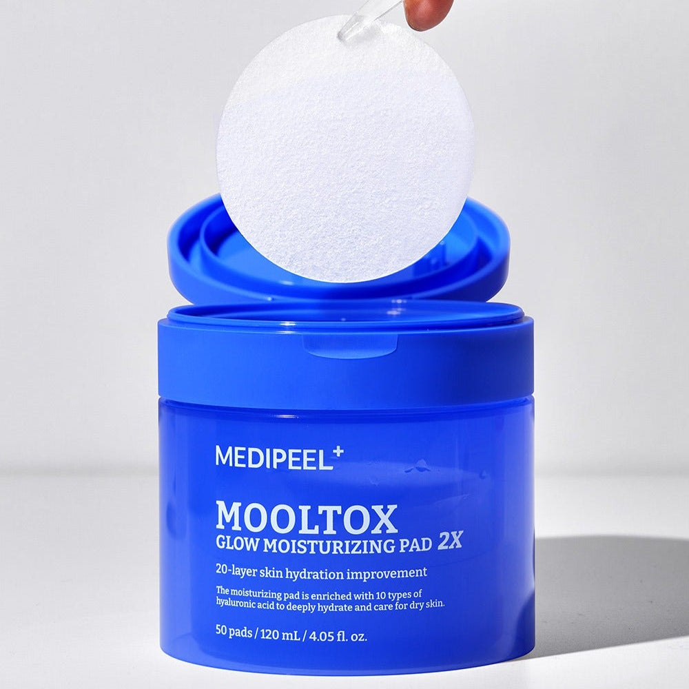 MEDIPEEL Water Tox Glow Moisturizing Pads 50 Sheets, pack bleu MEDIPEEL+ et pad blanc, sur fond clair, main tenant une pastille.
