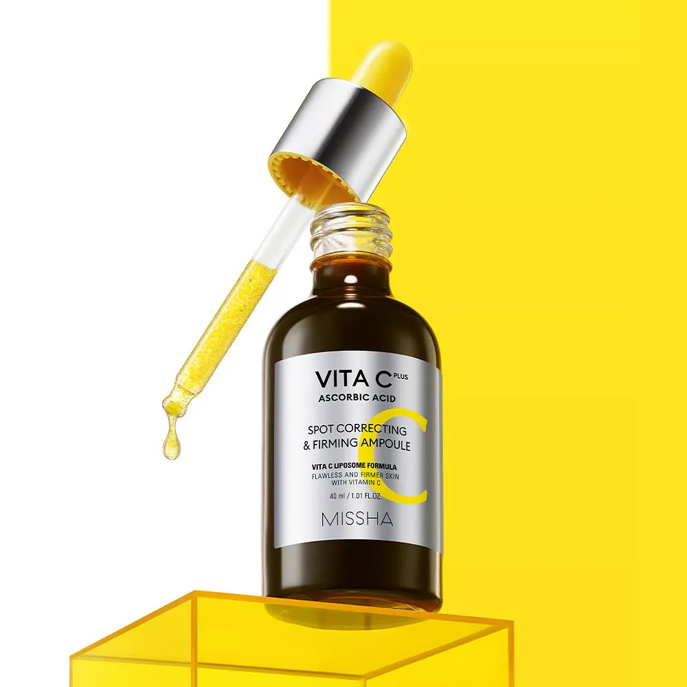 MISSHA Vita C Plus Blemish C Elasticity Ampoule 40ml : flacon avec goutte d’acide et fond jaune en studio.