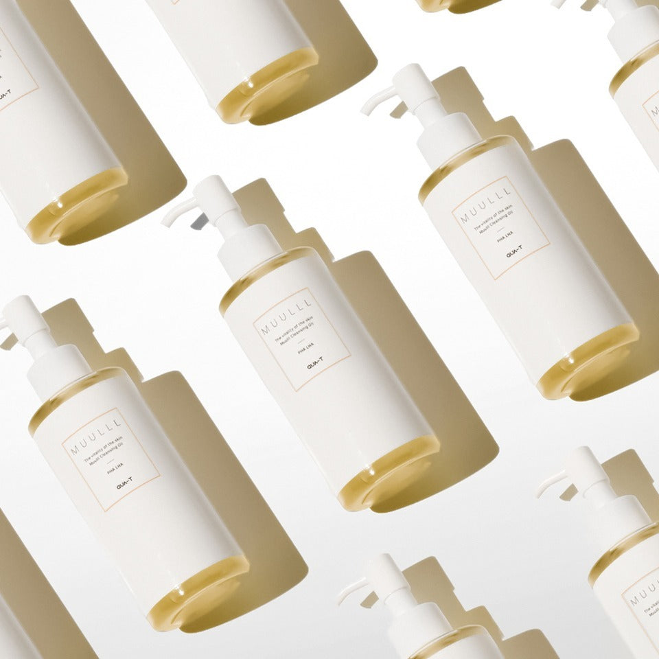 Bouteilles de QUA-T Cleansing oil 200ml affichées de manière artistique.