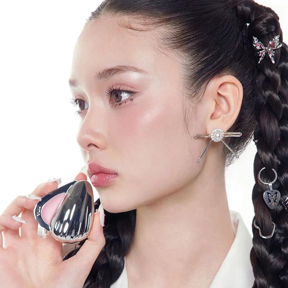 NAMING Blurry Cheek Balm 3g : femme appliquant un maquillage des joues, produit de la marque NAMING sur fond clair
