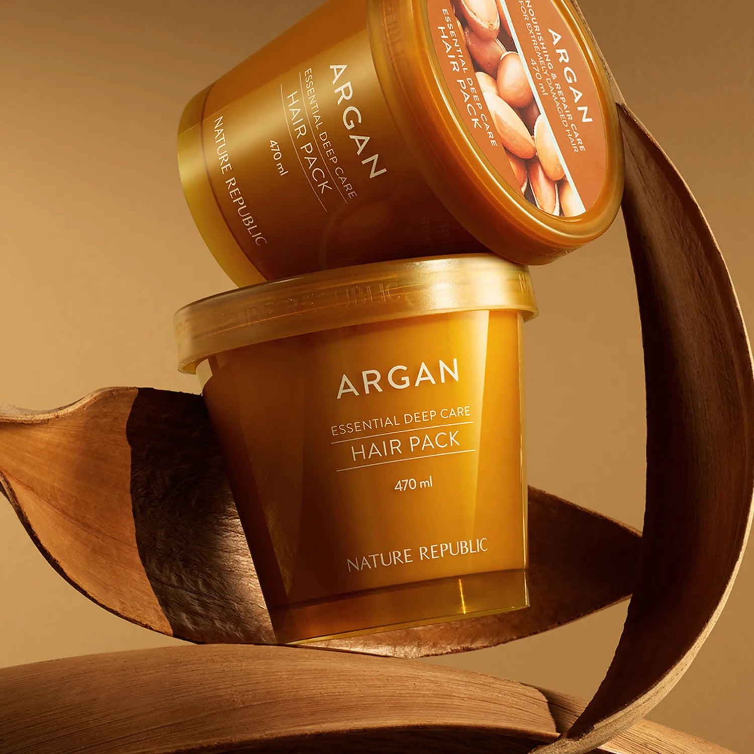 NATURE REPUBLIC Essential Deep Care Hair Pack 470ml, pot et rubans d’argan sur fond bois, photo produit en gros plan