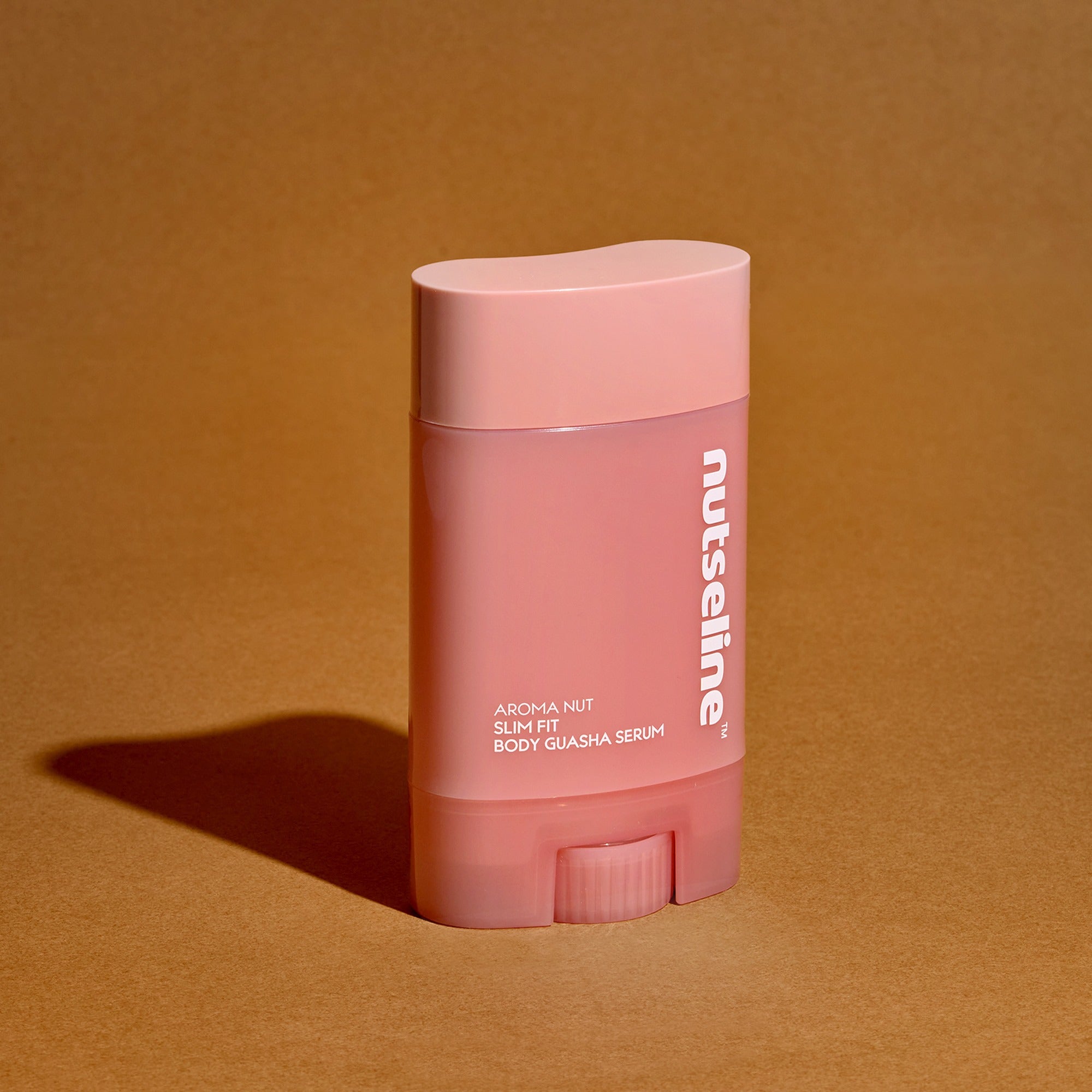 NUTSELINE Aroma Nut Slim Fit Body Guasha Serum 60ml de la marque NUTSELINE, pot rose sur fond beige.