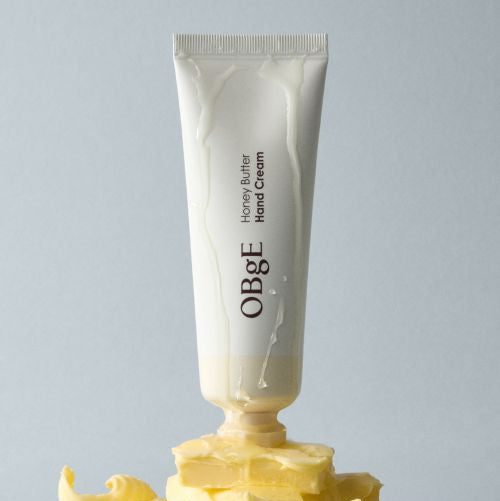 OBGE Honey Butter Hand Cream 50ml, crème mains de la marque OBGE sur fond clair, photo produit avec gouttes de miel