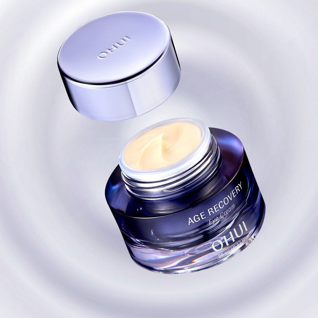 OHUI Age Recovery Eye Cream 25 mL, pot bleu et crème jaune sur fond clair, crème contour des yeux anti-âge