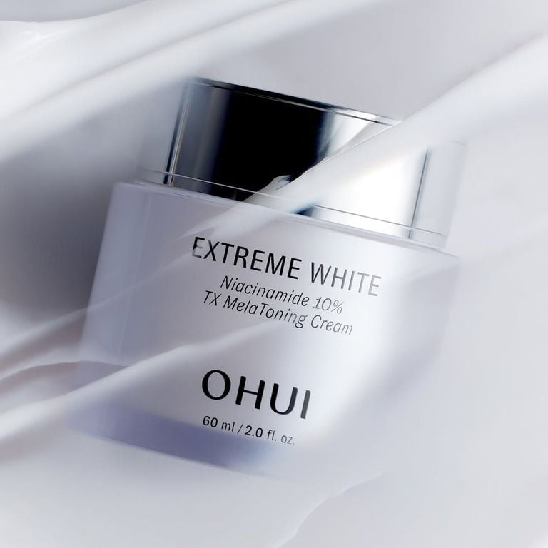 OHUI Ultimate Cover Denier Pact + Extreme White Niacinamide 10% TX Melatoning Cream 60ml : flacon “Extreme White” sur tissu blanc.