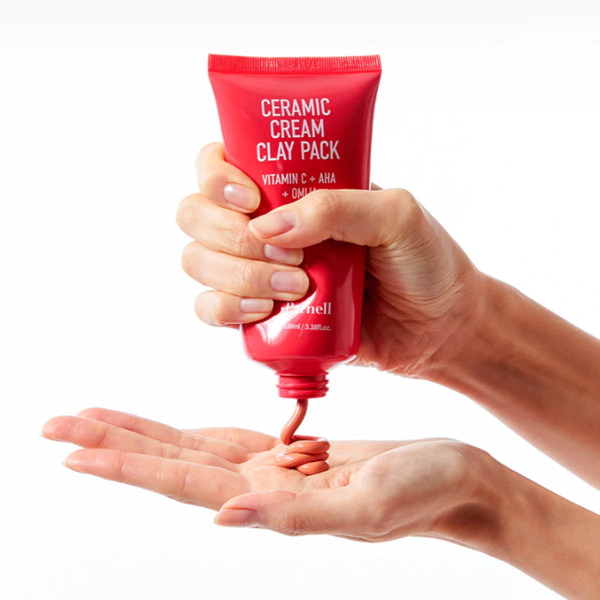 PARNELL AHA Omija Ceramic Cream Clay Pack 100ml, tube rouge tenu dans les mains, fond blanc, crème argile AHA/Céramic
