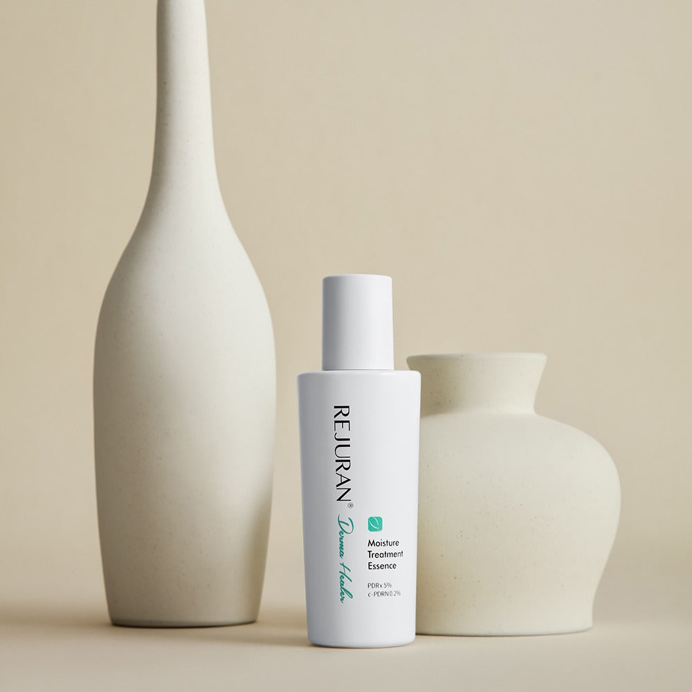REJURAN Derma Healer Moisture Treatment Essence 70g : flacon blanc REJURAN sur décor minimal, vase et crème, vue produit