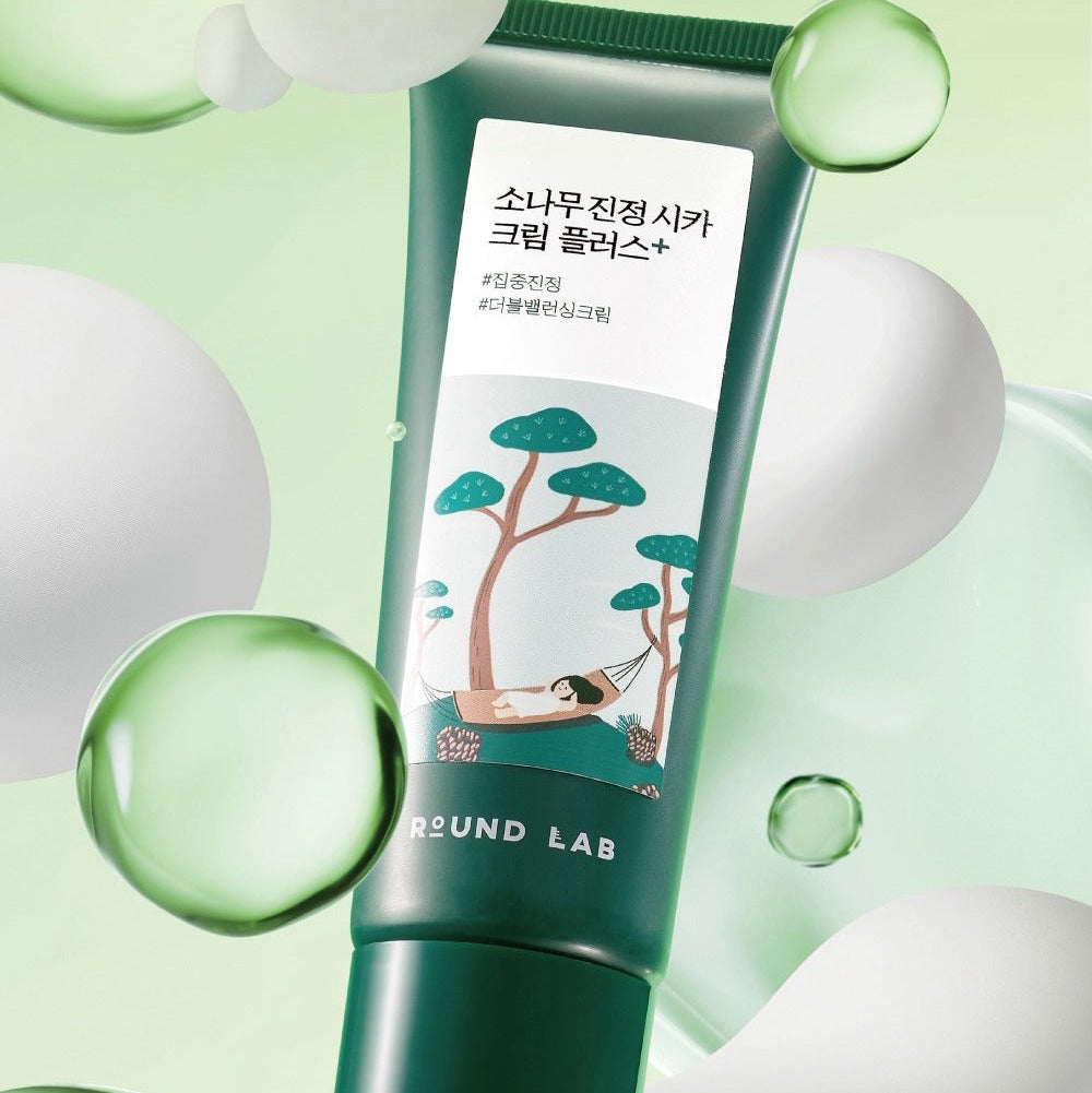 ROUND LAB Pine Calming Cica Cream Plus 60ml : crème apaisante Cica, tube vert sur fond vert avec bulles et feuilles.