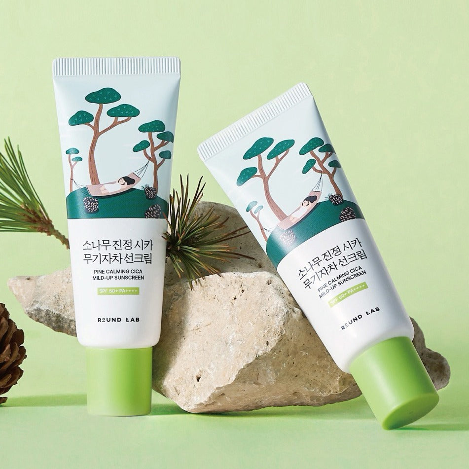 ROUND LAB Pine Tree Calming Cica Mineral Sunscreen 40ml, tubes sur fond vert avec pierres et végétation, marque ROUND LAB