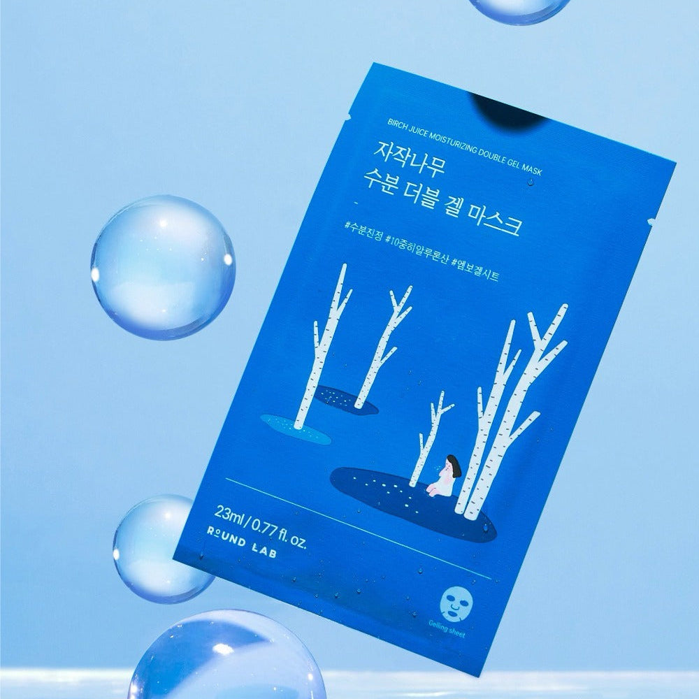 ROUND LAB Birch Moisture Double Gel Mask (10 sheets) en emballage bleu avec boulettes d'eau et arbres en arrière-plan.