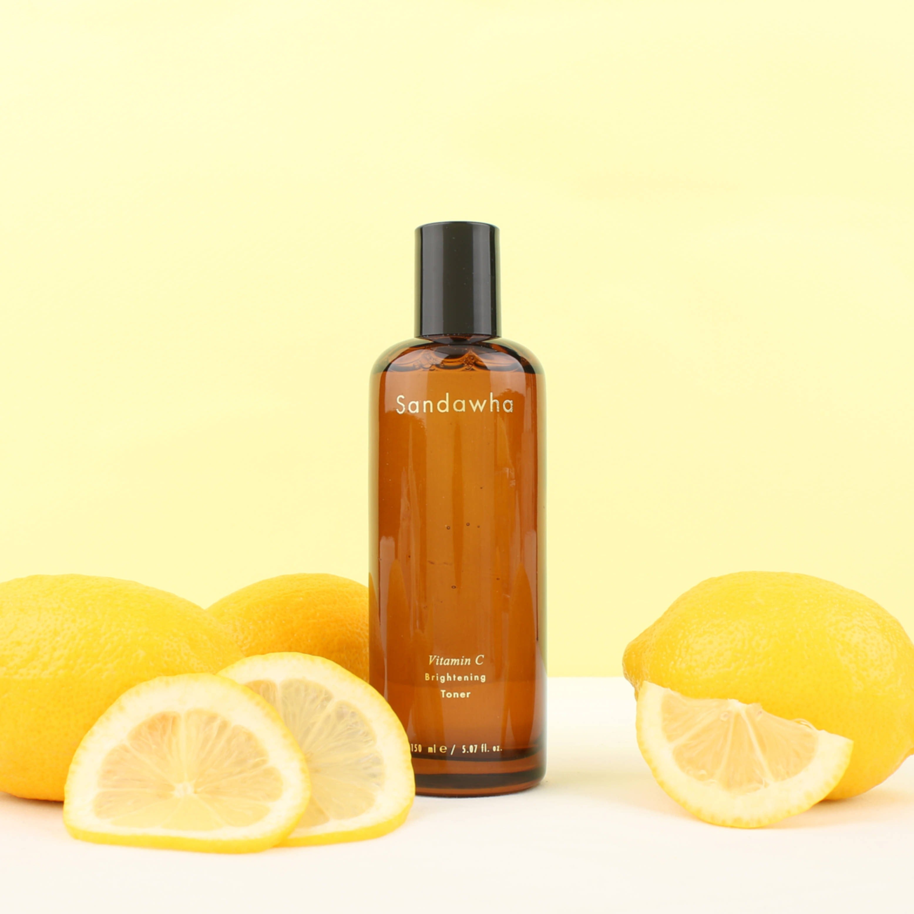 SANDAWHA Vitamin C Whitening Toner 150ml, bouteille avec citrons sur fond jaune en studio, marque Sandawha