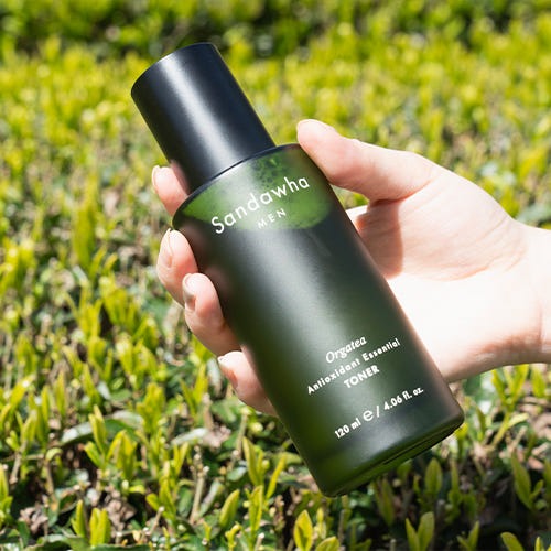 Toner pour homme SANDAWHA For Men orgatea Antioxidant Essential Toner 120ml tenu dans une main avec fond de végétation