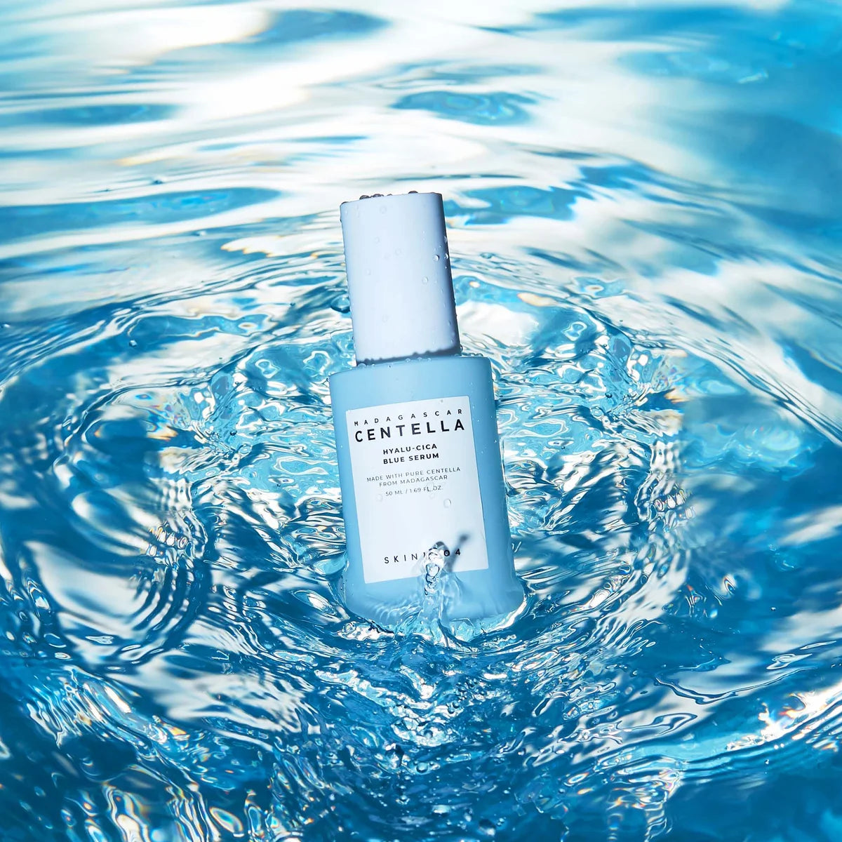 SKIN1004 Madagascar Centella Hyalu-Cica Blue Serum 50ml, bouteille bleue sur fond d’eau en contexte skincare, marque SKIN1004