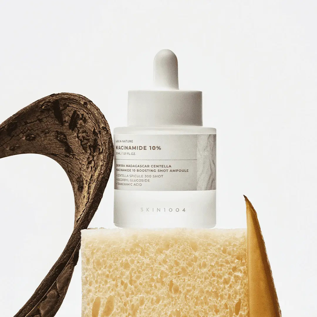 Décris l'image en français : SKIN1004 Madagascar Centella Niacinamide 10 Boosting Shot Ampoule 30ml, flacon sur fond blanc, centella.
