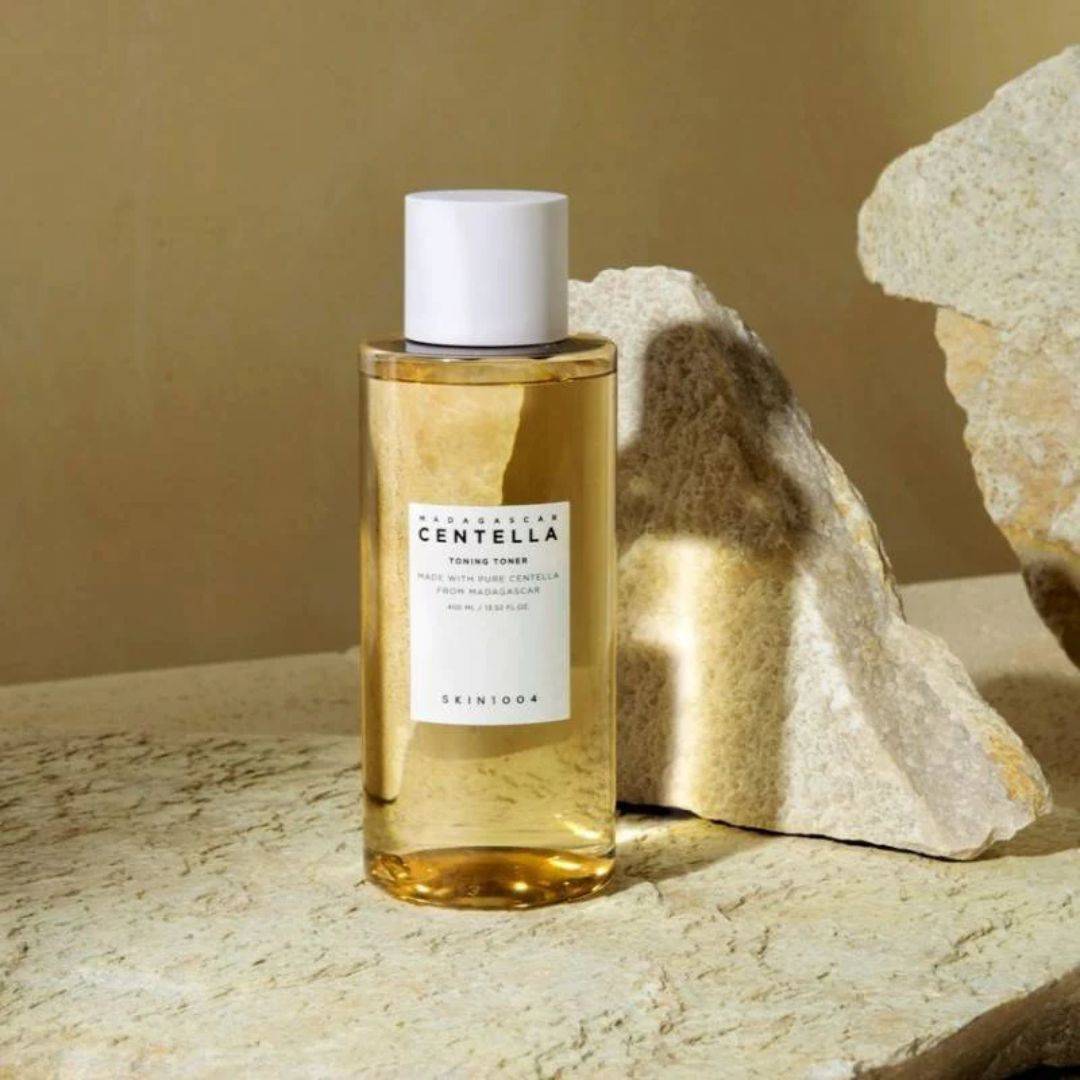 SKIN1004 Madagascar Centella Toning Toner 400ml de SKIN1004, flacon ambre sur pierres et texture naturelle, décor spa.