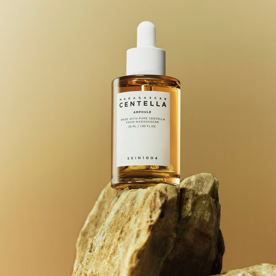 Photo du produit SKIN1004 Madagascar Centella Ampoule 55ml sur une pierre, soin naturel hydratant et apaisant.
