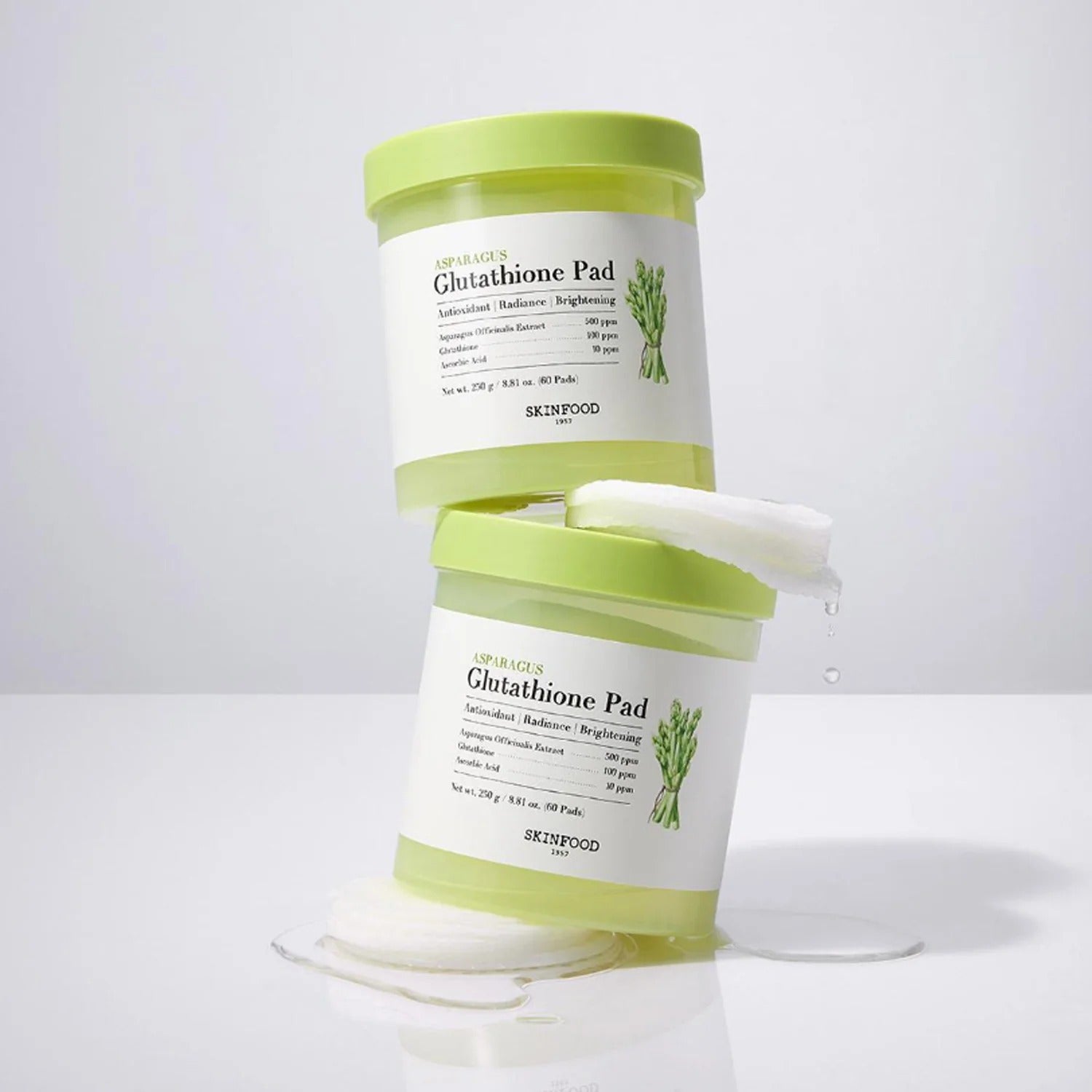 Deux pots de SKINFOOD Asparagus Glutathione Pad (60 Pads) empilés avec des tampons visibles, fond blanc.