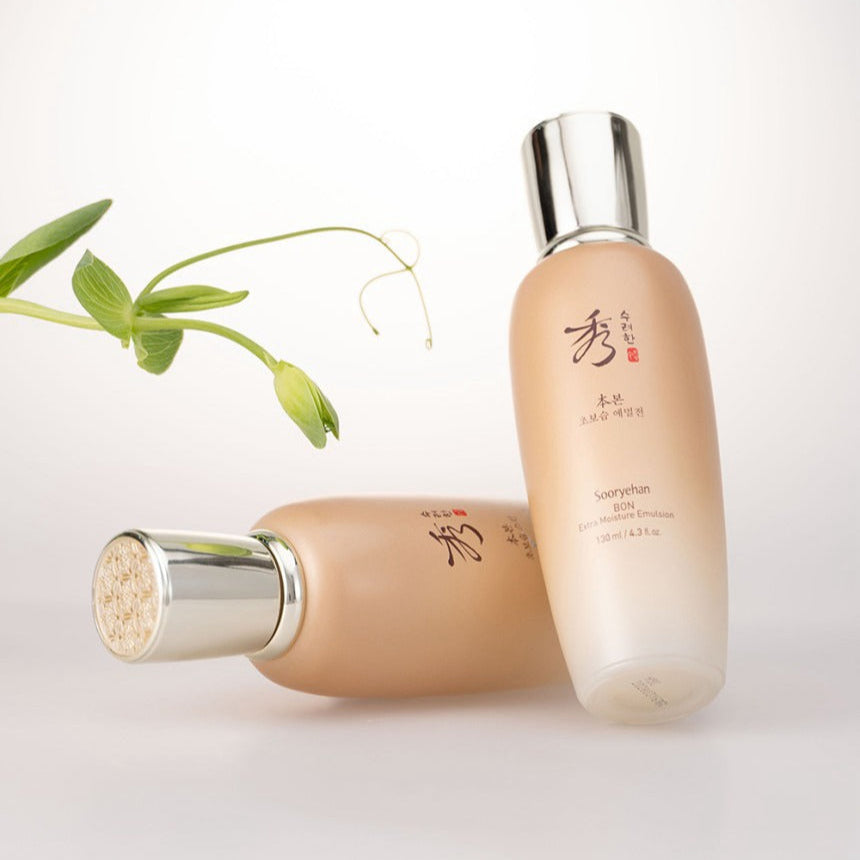 SOORYEHAN Bon Ultra-Moisturizing Emulsion 130ml, flacon crème beige sur fond blanc, feuilles vertes et lumière douce.