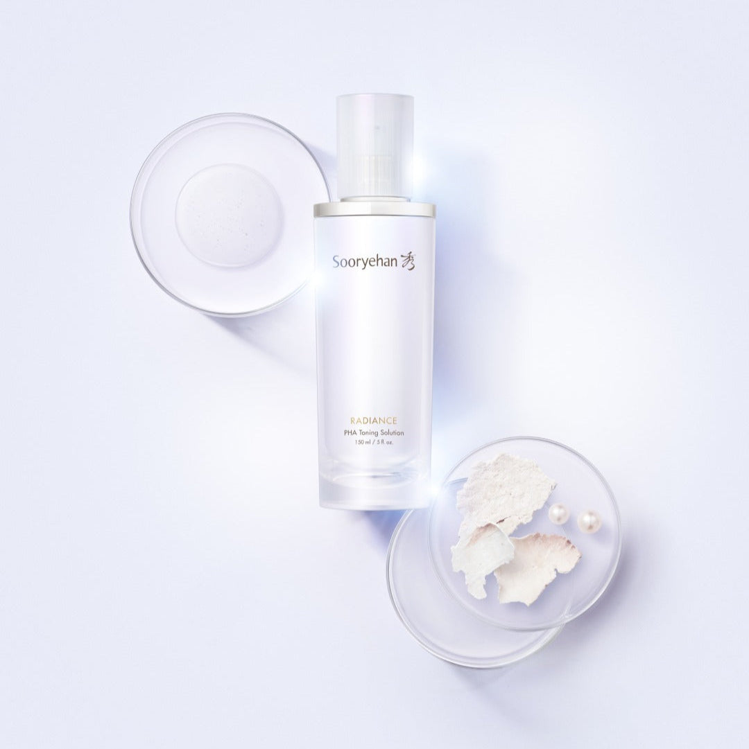 Solution tonifiante quotidienne SOORYEHAN Radiance PHA 150ml pour éclat de la peau, entourée d'accessoires beauté élégants.