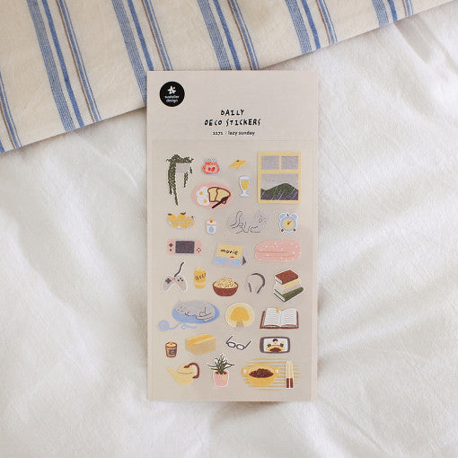 SUATELIER Lazy Sunday Stickers sur papier, bureau déco, style rétro et motifs du dimanche, sur fond tissu bleu clair.