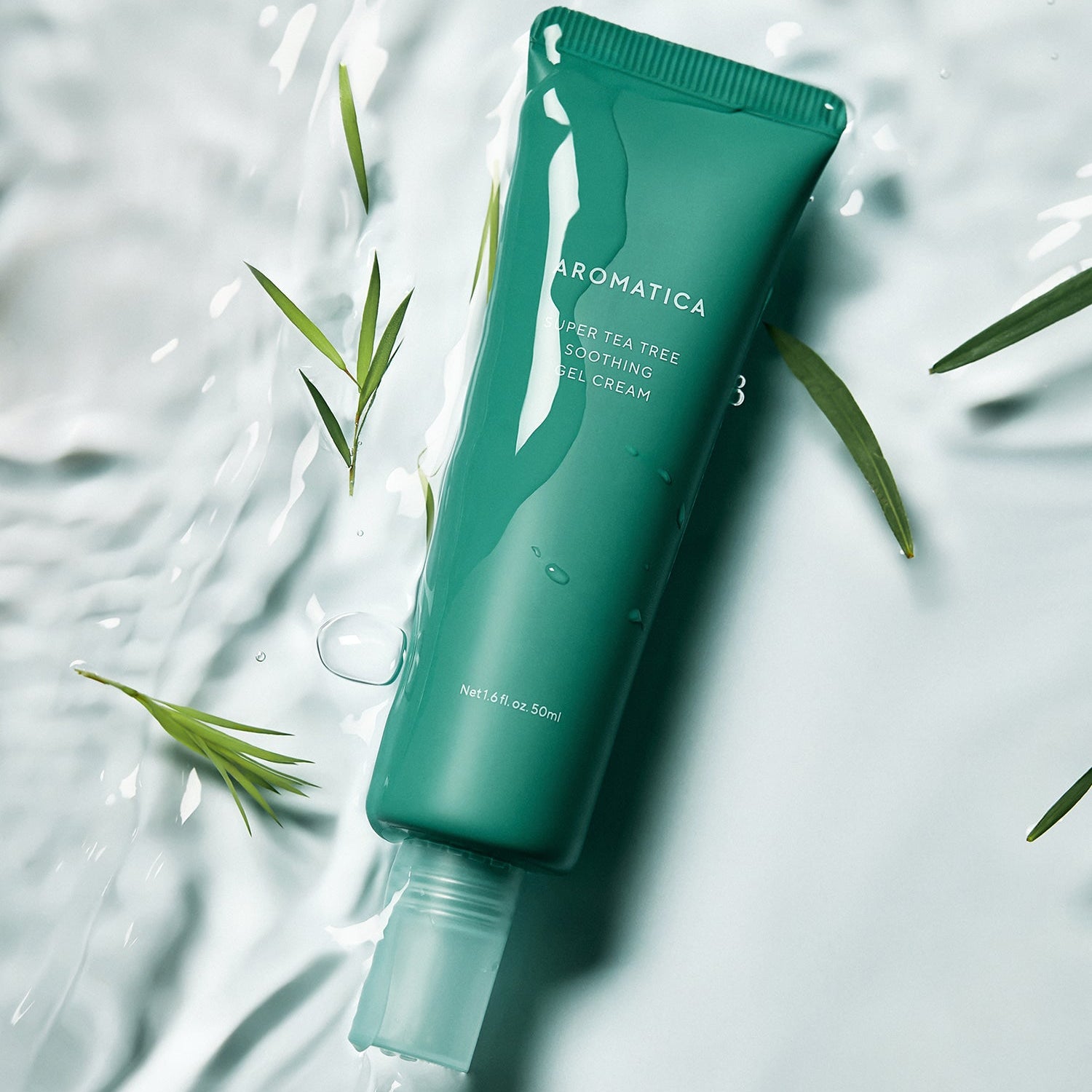 Gel apaisant AROMATICA Super Tea Tree Soothing Gel Cream 50ML sur fond aquatique avec feuilles de thé vertes.