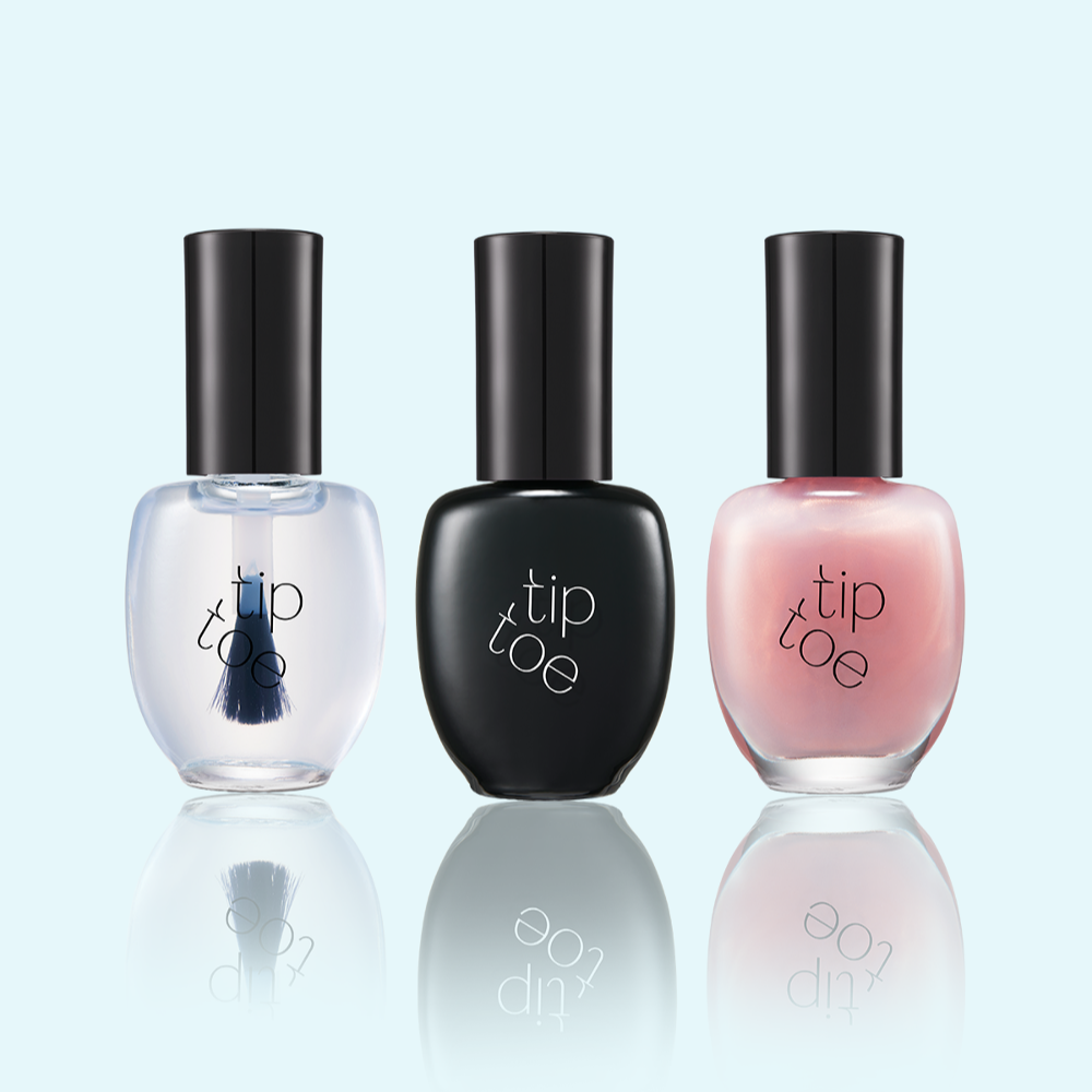 Décris l'image en français : TIP TOE Sheer Topcoat Nail Polish, bouteilles x tip toe sur fond bleu clair, vue produit.