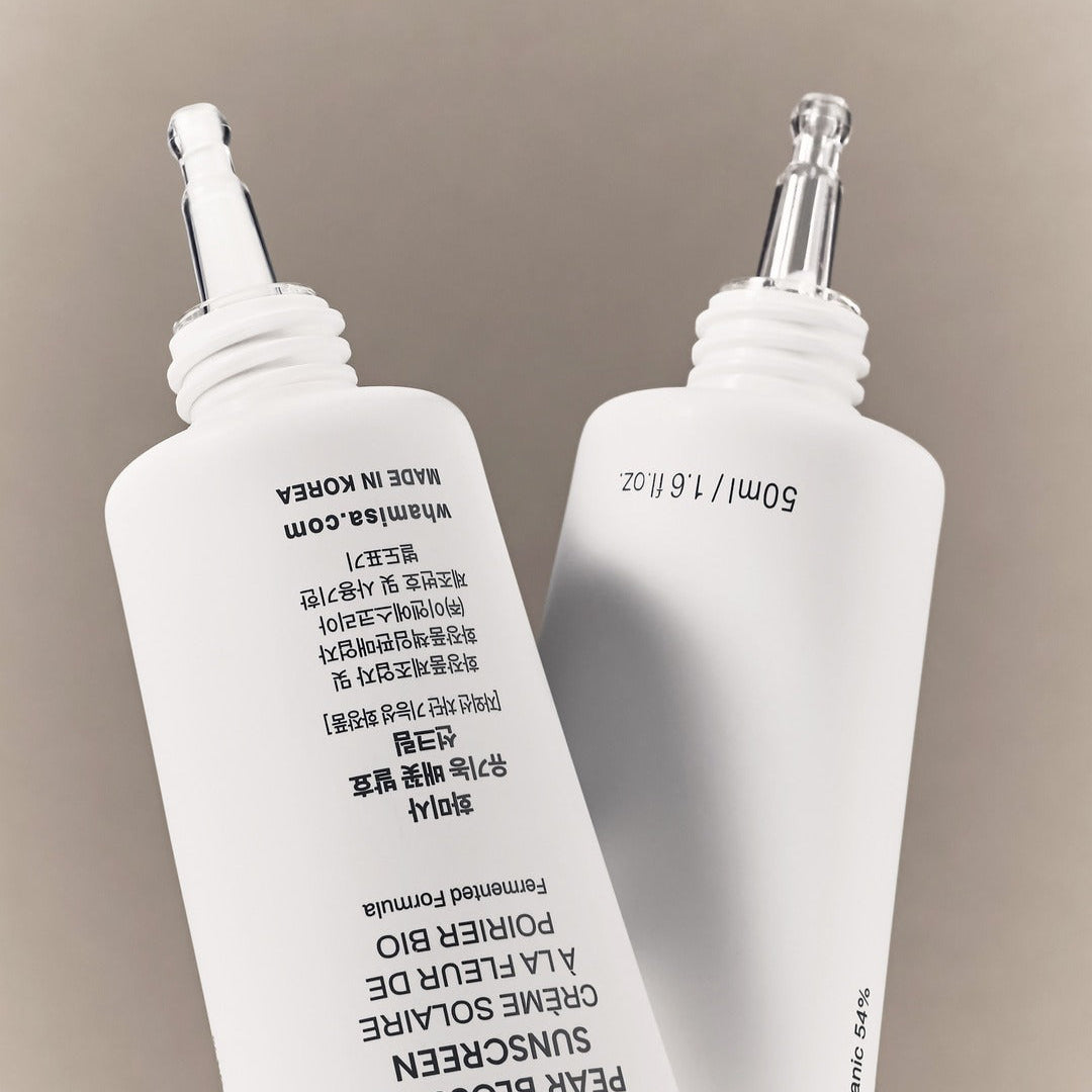 WHAMISA Organic Pear Blossom Fermented Sunscreen 50ml : flacons blancs sur fond beige, marque WHAMISA en gros.