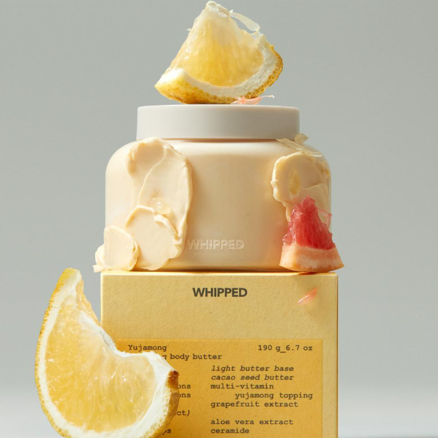 WHIPPED Yuja Grapefruit Vegan Topping Body Butter Light 190g, pot cosmétique blanc, tranches de yuzu et pamplemousse, fond clair.