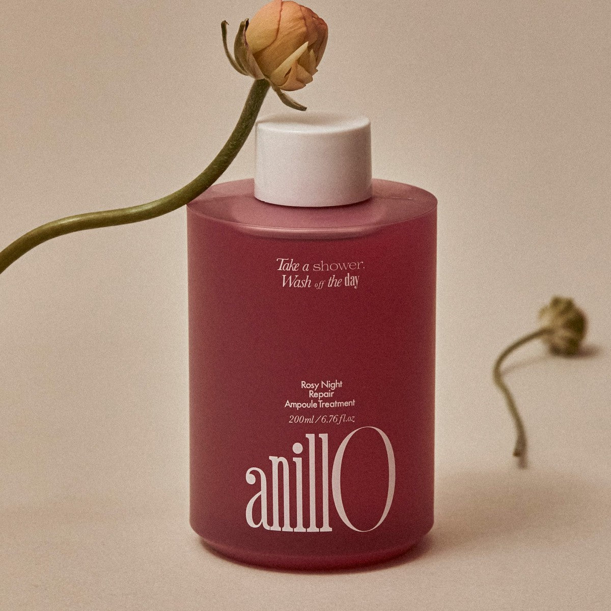 ANILLO Rosy Night Repair Ampoule Treatment 200ml, flacon rouge sur fond beige, rose en déco, soin visage nocturne
