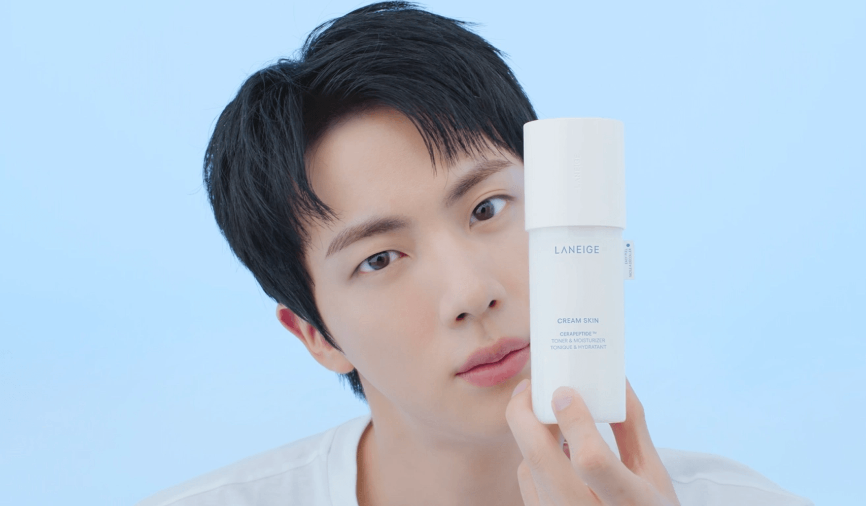Réveillez-vous radieuse : Mon avis honnête sur les produits Laneige — homme tenant une bouteille Laneige sur fond bleu ciel