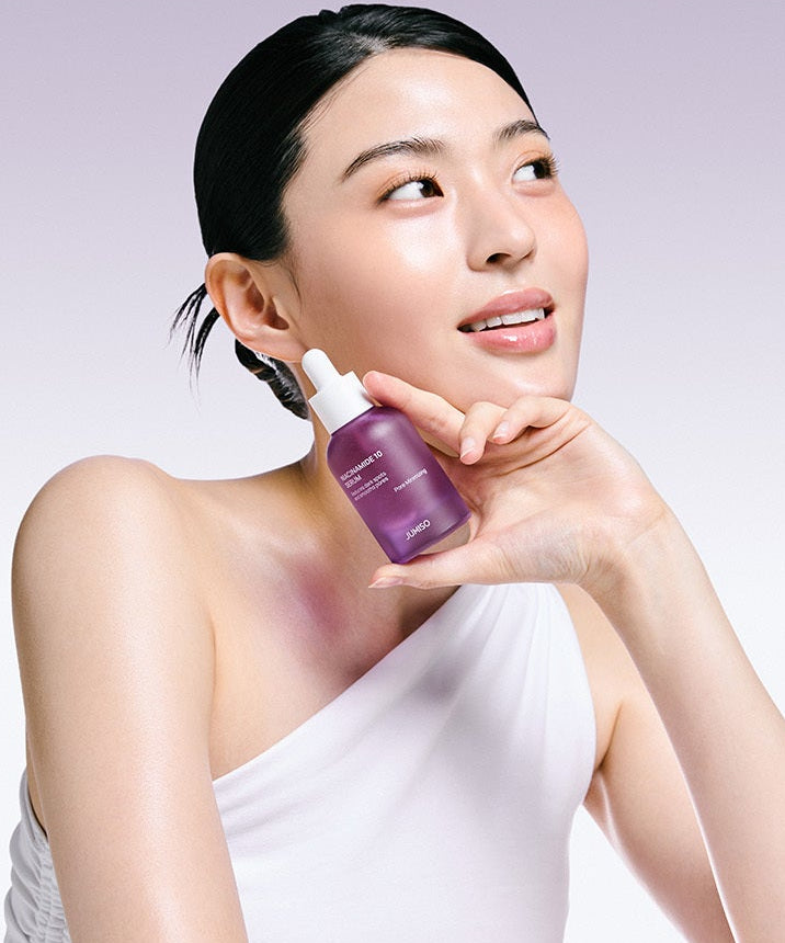 Femme souriante tenant JUMISO Niacinamide 10 Serum 40ml devant un fond violet.