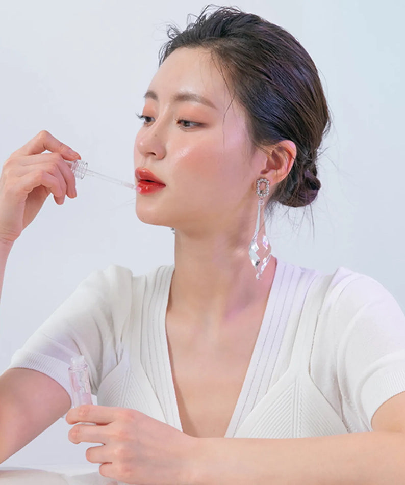 ROMAND Glasting Water Gloss de la marque ROMAND, maquillage sur lèvres, femme en gros plan fond clair
