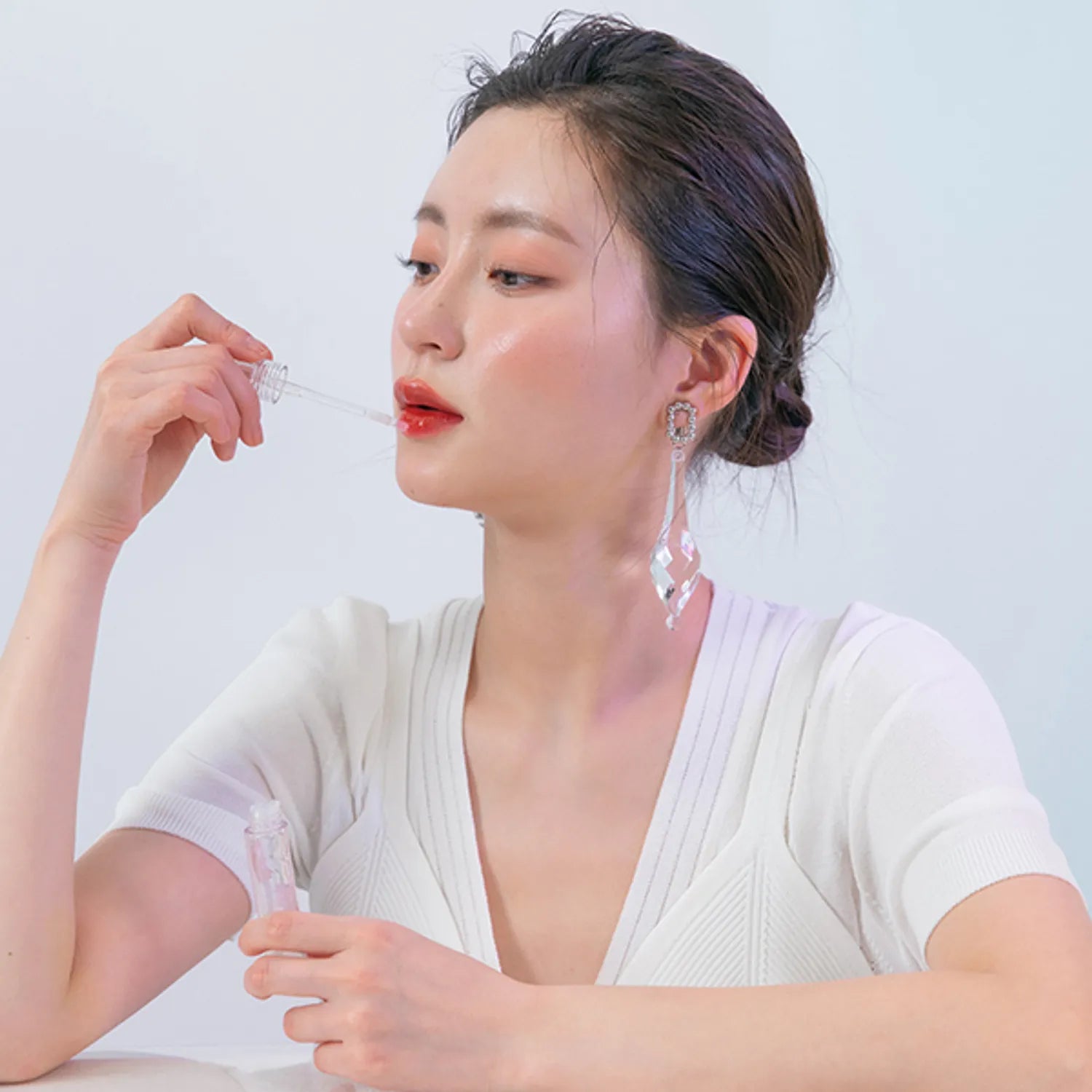 ROMAND Glasting Water Gloss de la marque ROMAND, maquillage sur lèvres, femme en gros plan fond clair