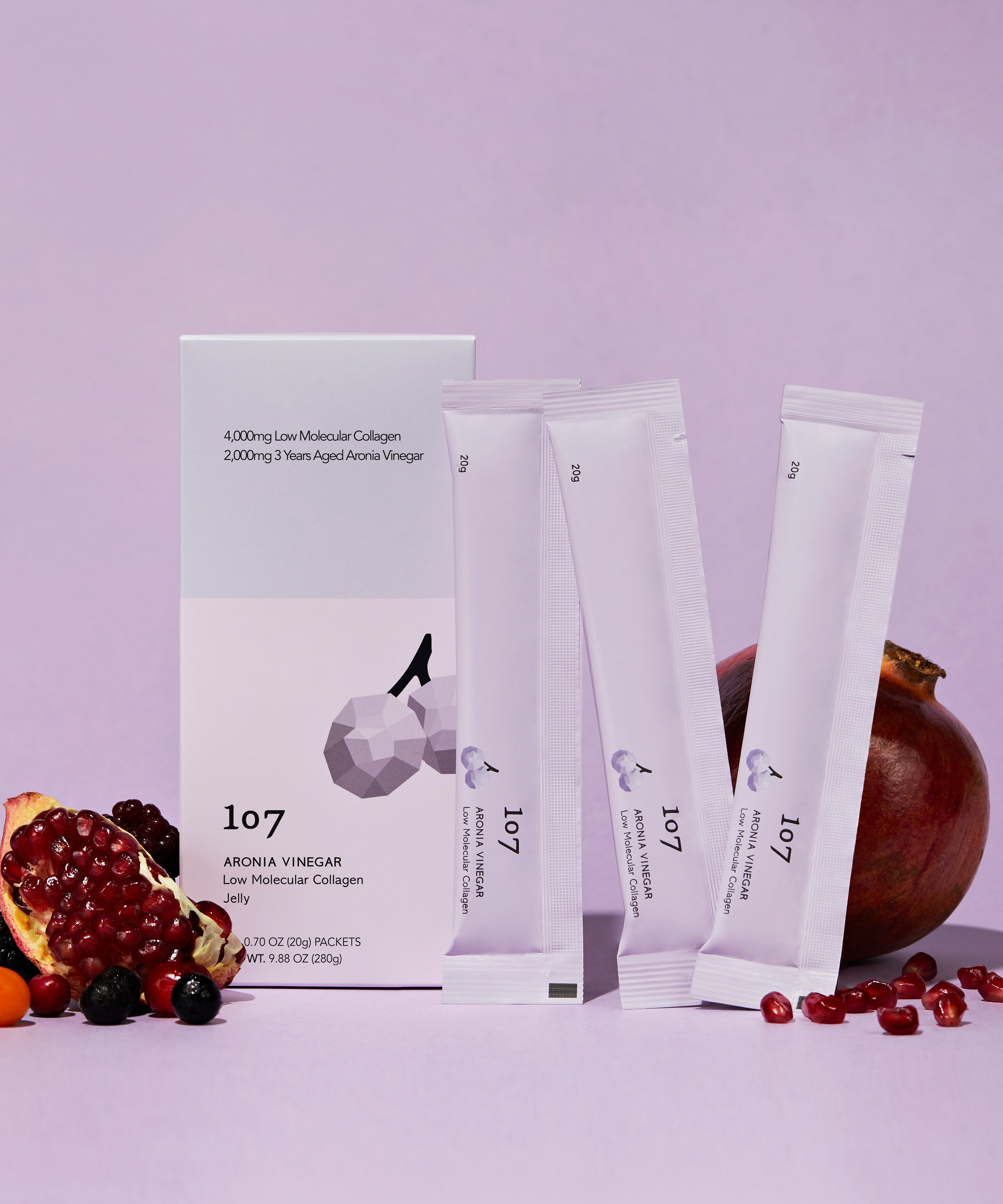 107 Aronia Vinegar Low Molecular Collagen 20g x 14 Packets avec fruits autour, emballages élégants en arrière-plan.