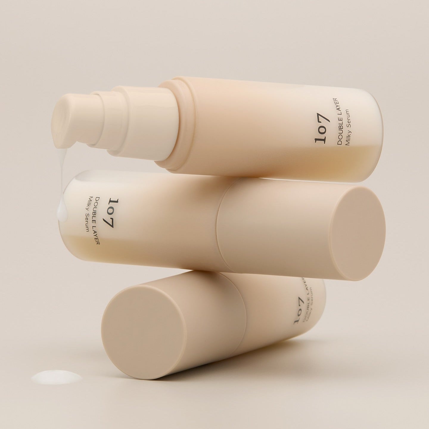 Décrivez l'image en français : 107 Double Layer Milky Serum 50ml, flacons crème beige de la marque 107 sur fond clair.