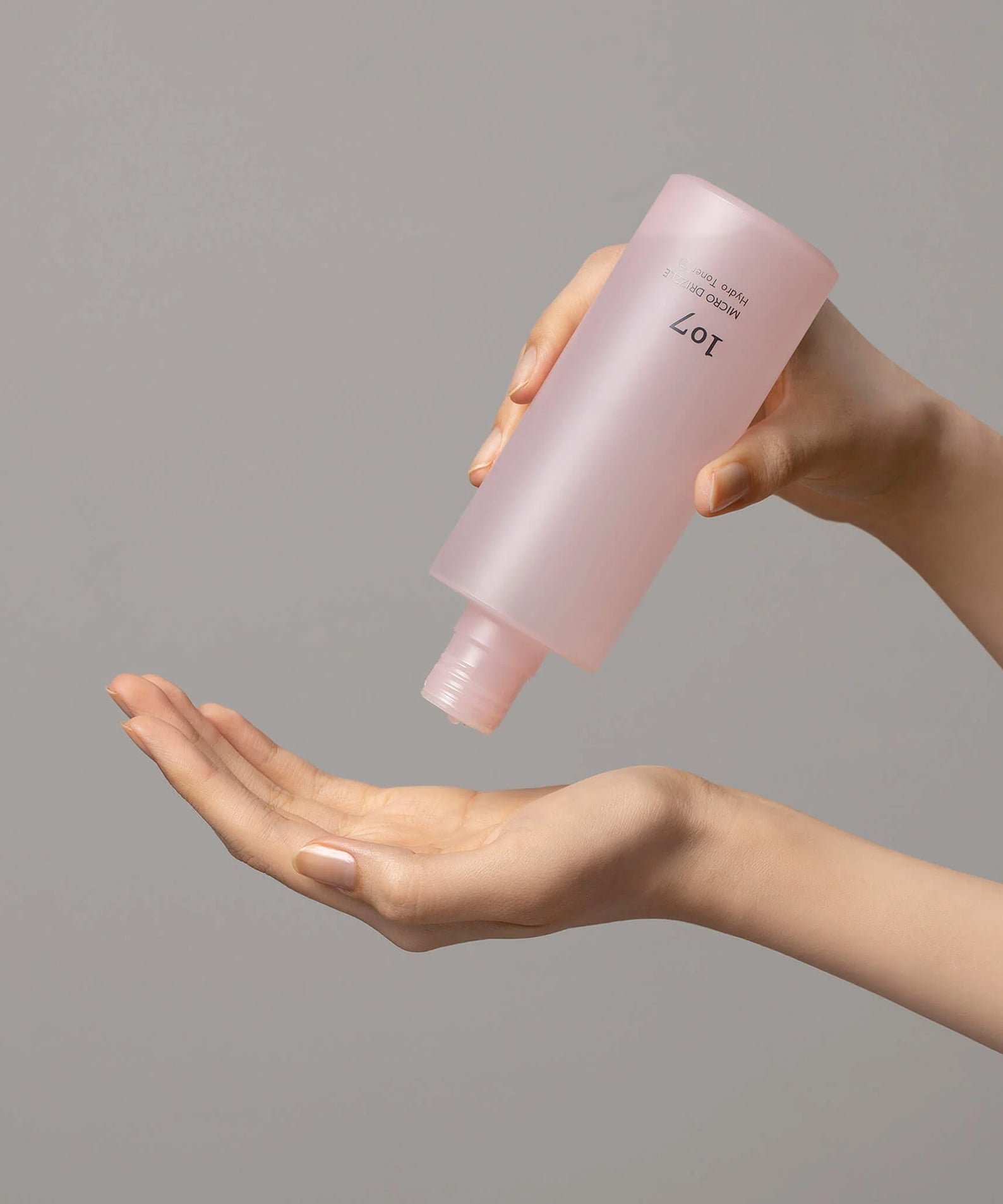 107 Micro Drizzle Hydro Toner 155ml versé dans la main, révélant sa texture hydratante.