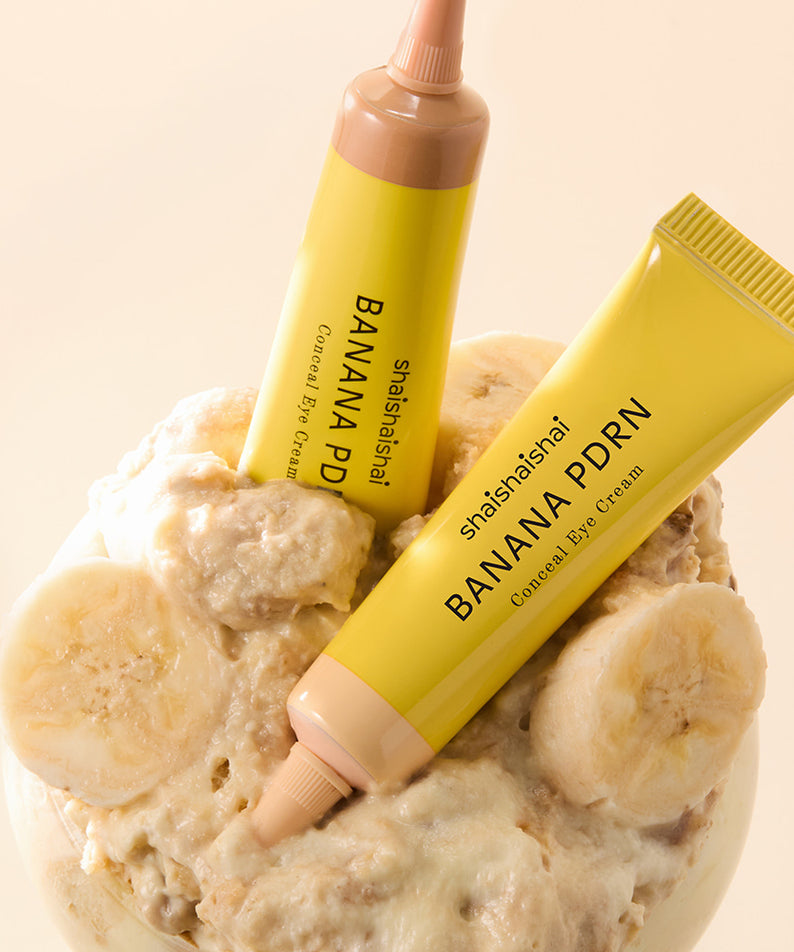 SHAISHAISHAI Banana PDRN Conceal Eye Cream 15ml, tubes jaunes sur fond beige avec tranches de banane, visuel produit