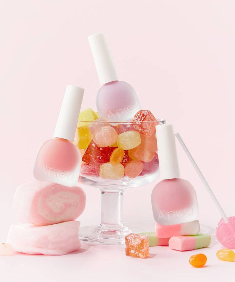 A'PIEU Juicy-Pang Water Blusher 8g : flacons rose sur fond pastel avec bonbons, marque A'PIEU en contexte maquillage.