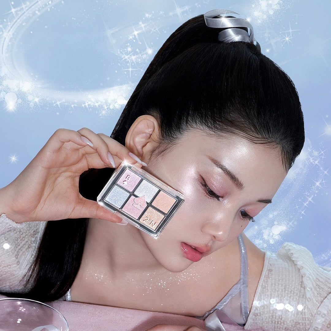 Photo produit 2AN  Better Me Eye Palette 4.5g : palette maquillage yeux tenue près du visage, marque 2AN, fond paillettes.